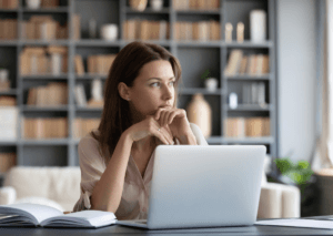 Zamyślona dziewczyna w biurze przy laptopie